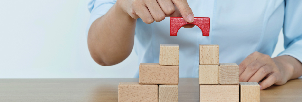 Close up of a hand piling up wooden blocks