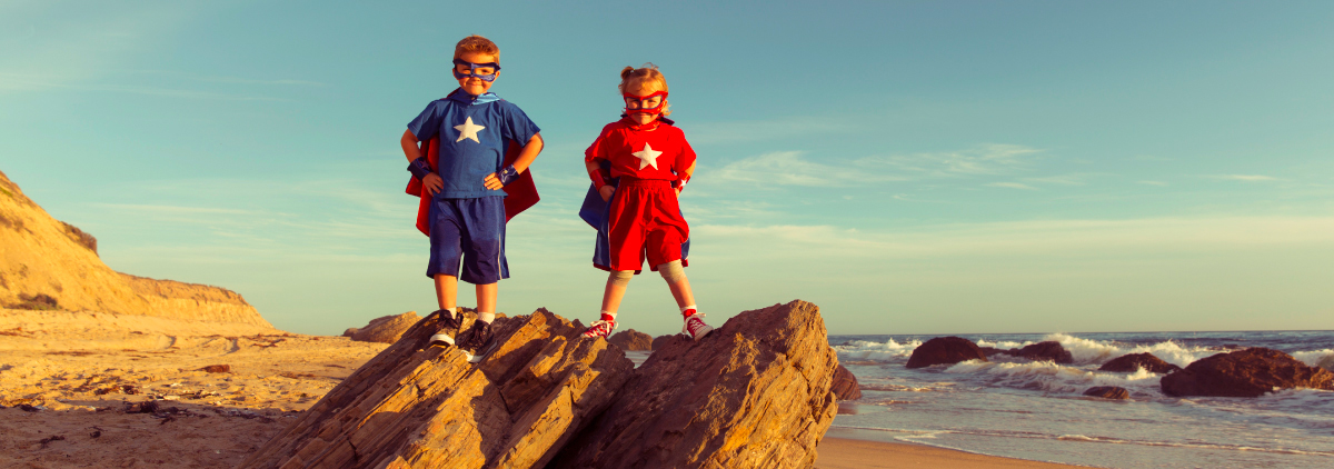 Children dressed as superheroes standing on a cliff