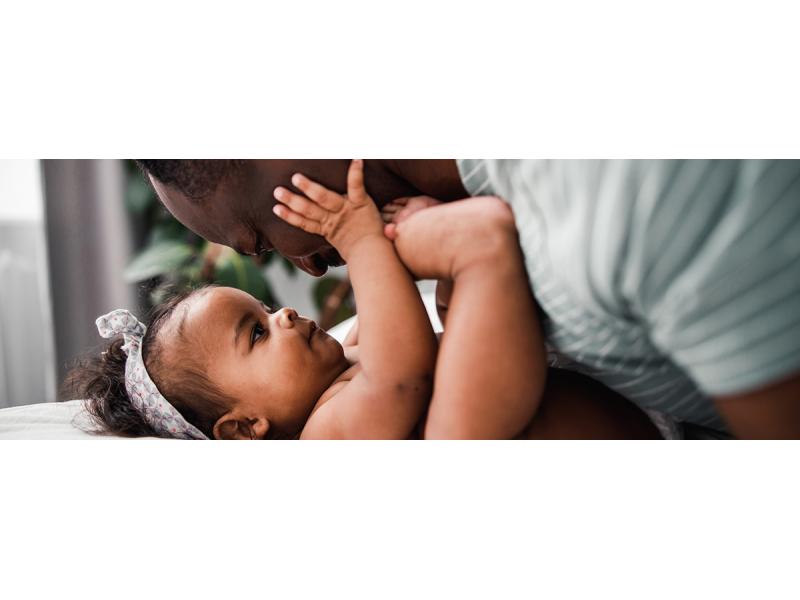 Black baby girl playing with her father's face