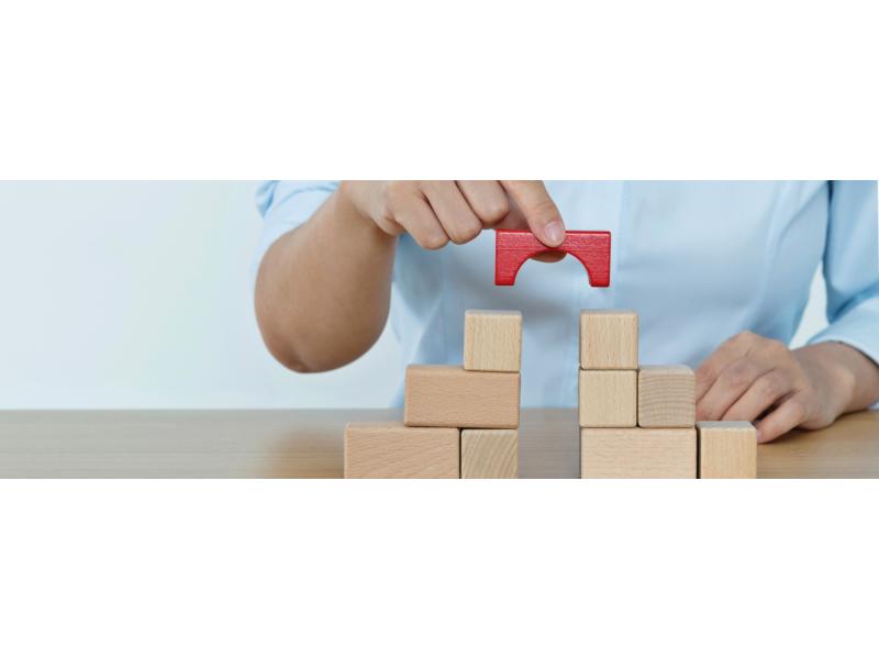 Close up of a hand piling up wooden blocks