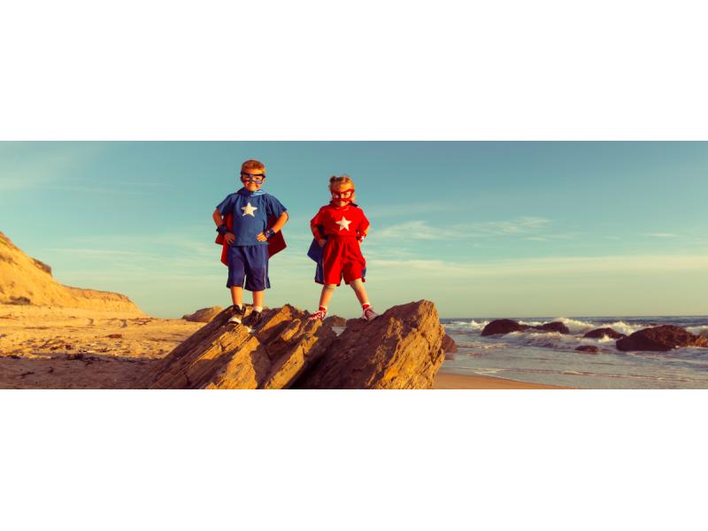 Children dressed as superheroes standing on a cliff